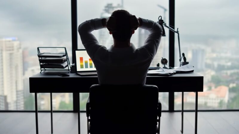 Investor Relaxing in his Office While Looking at Work Material. Concept for Importance of Net Cash Flow for Investors